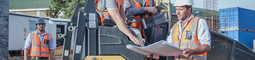 A male site manager discusses cost management in construction with construction workers