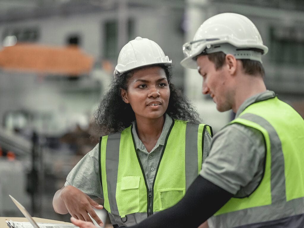 two construction workers discuss the safety management of construction sites before starting their project